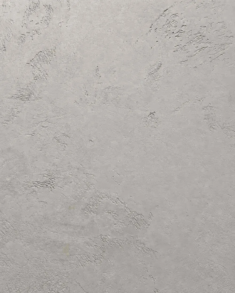 Close-up of pale gray Marmorino Venetian plaster with a matte stone texture and trowel marks