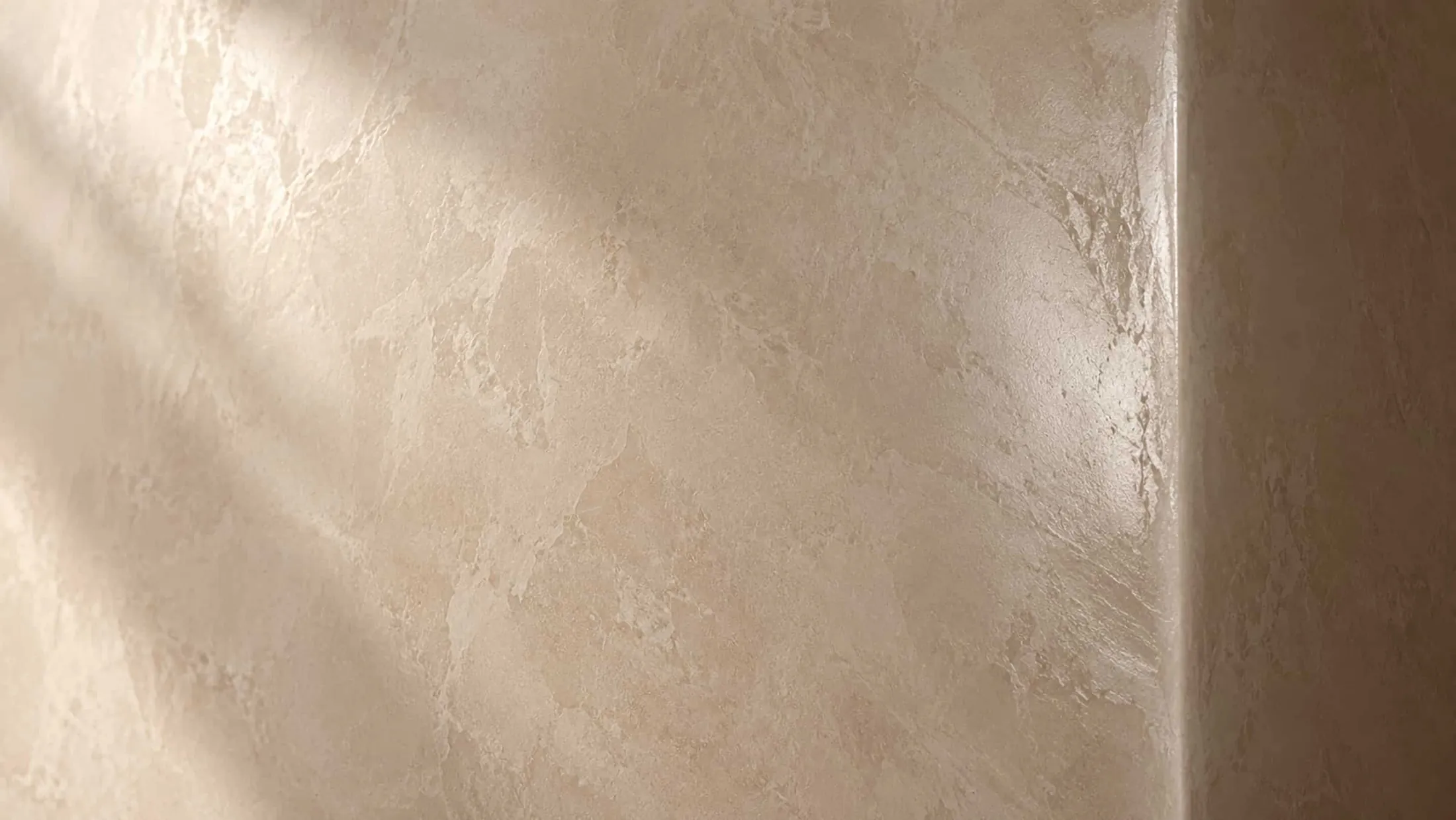 Polished Venetian plaster in warm ivory catching raking sunlight at an outside corner