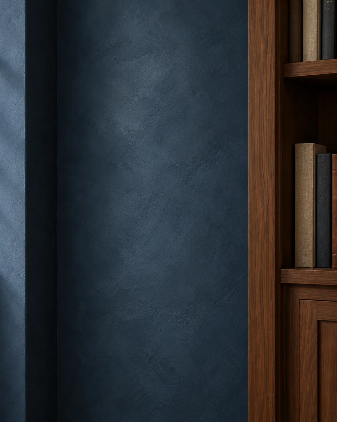 Close-up of deep navy Roman clay beside a walnut bookcase, with soft lighter clouds and a velvety matte surface